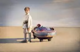 Little Boy Posing At The Side Of Star Wars Luke Skywalker Landspeeder