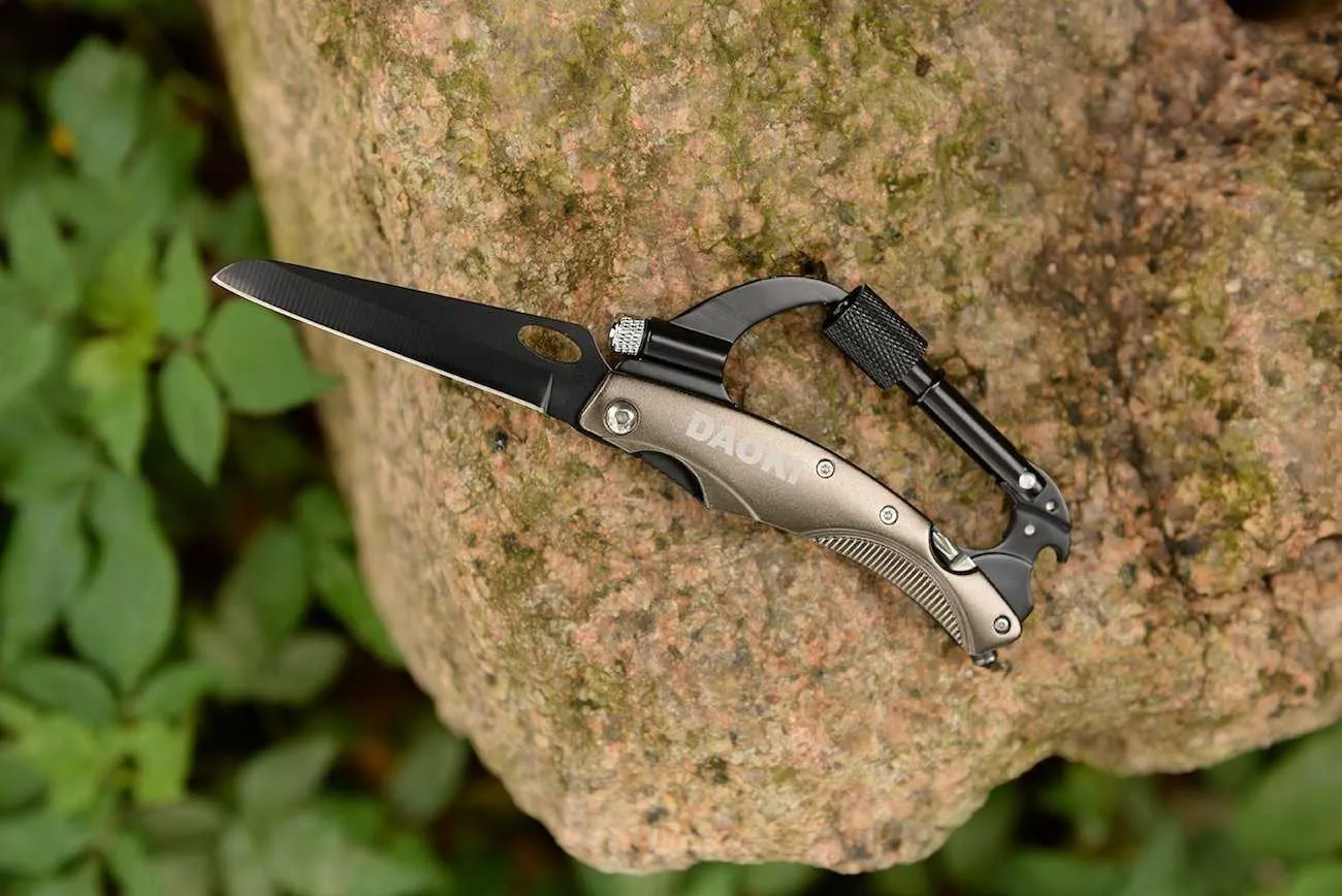 Daoki 7In1 Multifunctional Carabiner Placed On A Rock With Open Knife