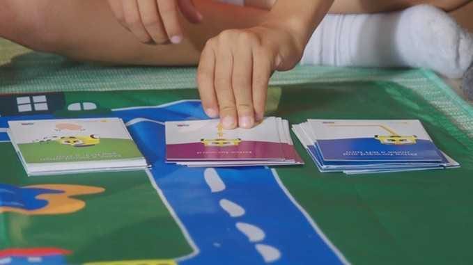 Kid Picking Up Next Algobrix Activity Card In The Stack